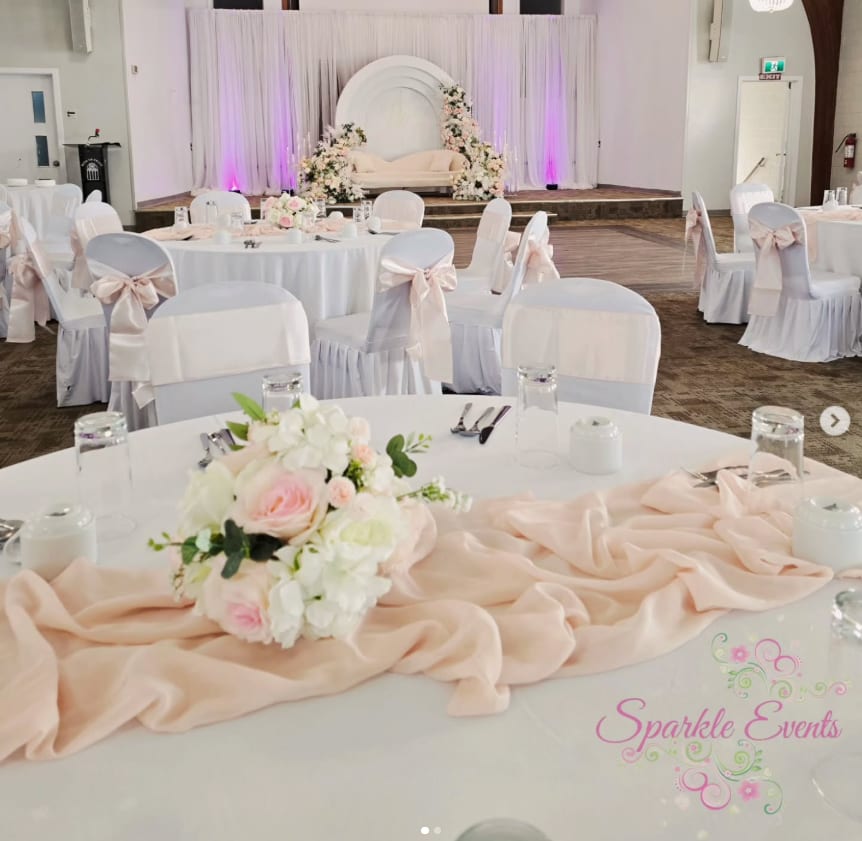 A wedding styled by Sparkle Events with layered florals and draped fabric